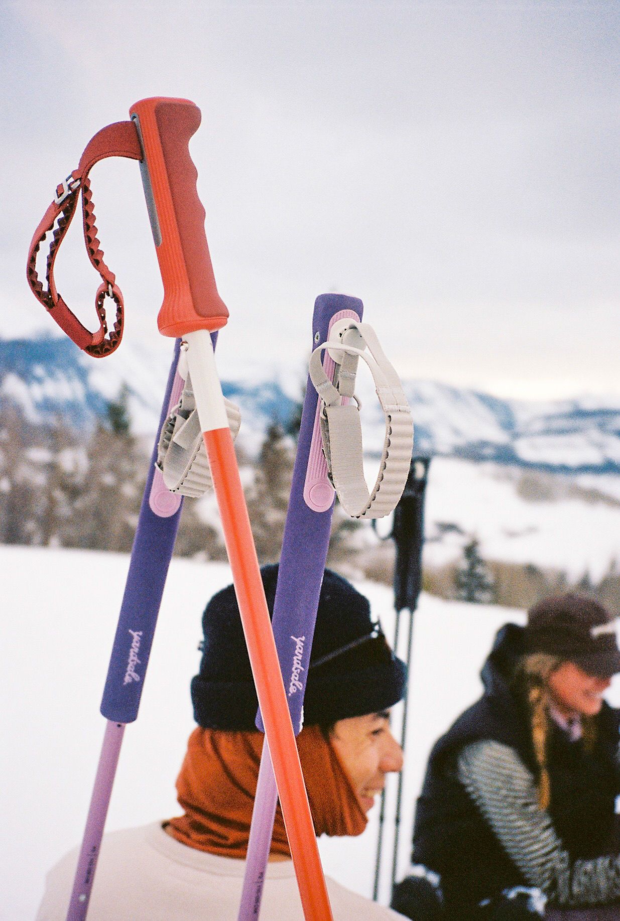 An image of two people with ski poles in the foreground 