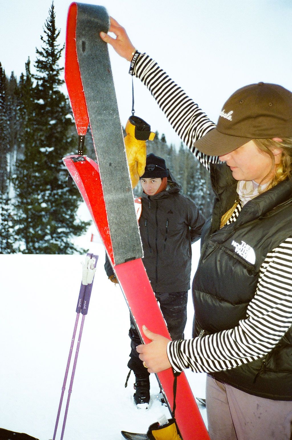 An image of a woman putting skins on backcountry skis 