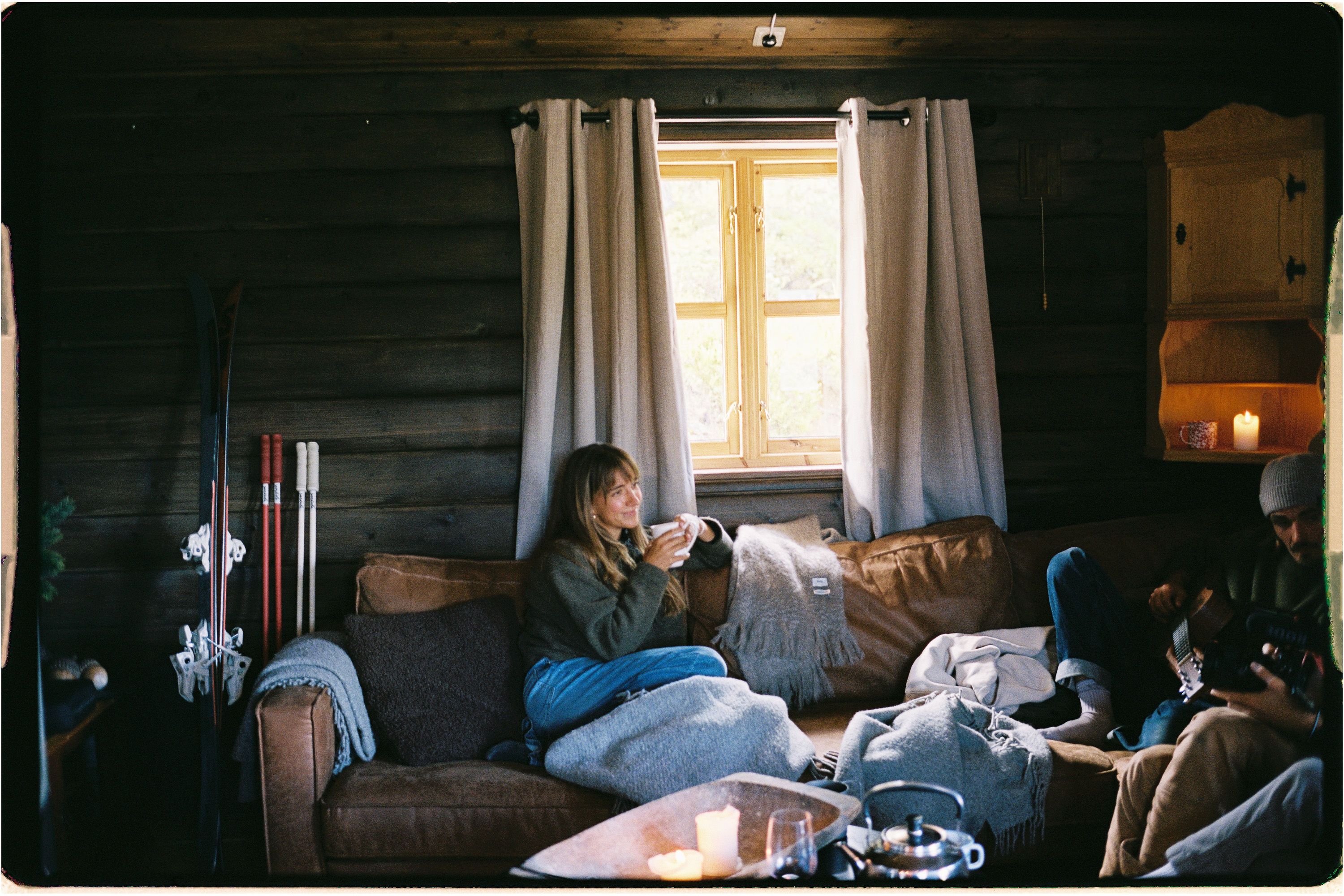 An image of a person sitting on a couch drinking coffee