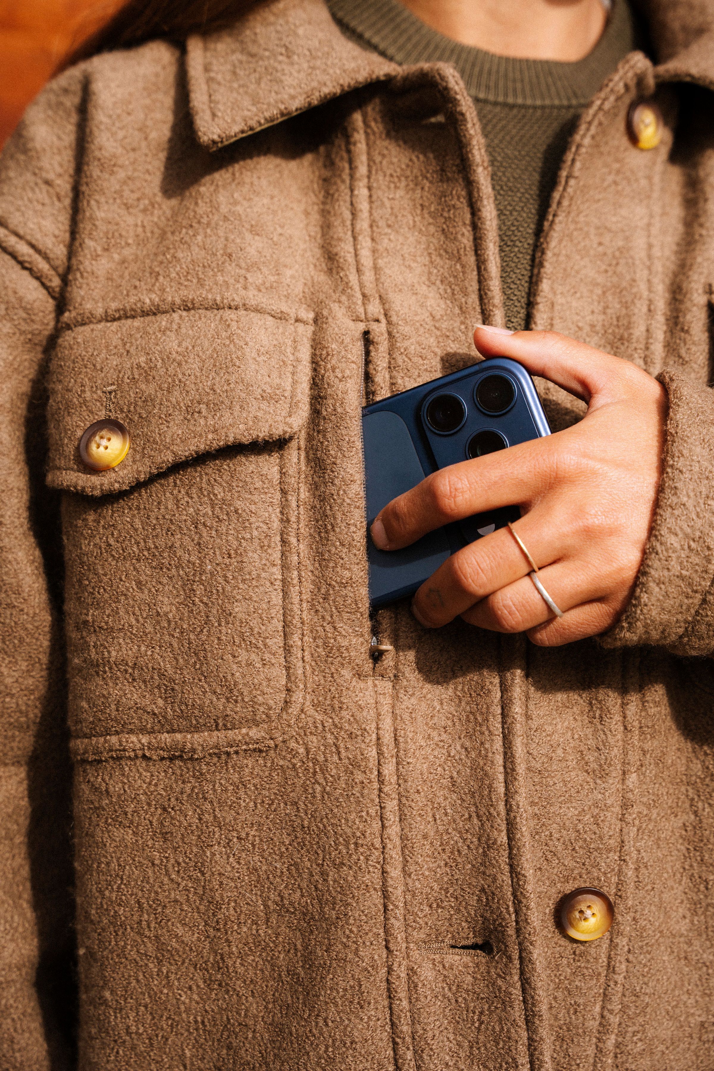 An image of someone putting a phone into a zippered pocket