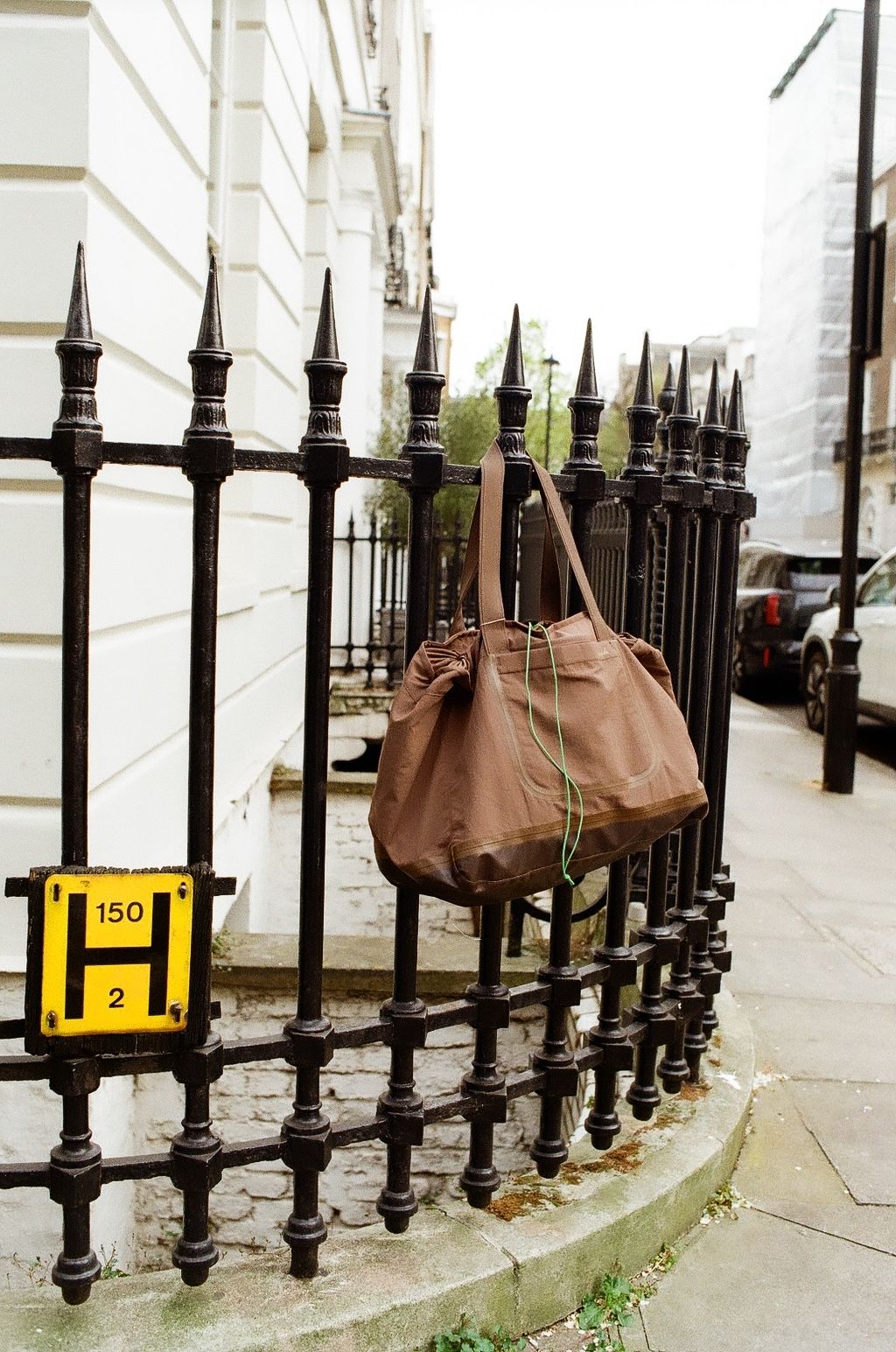 An image of a bag hung on an iron fence in London