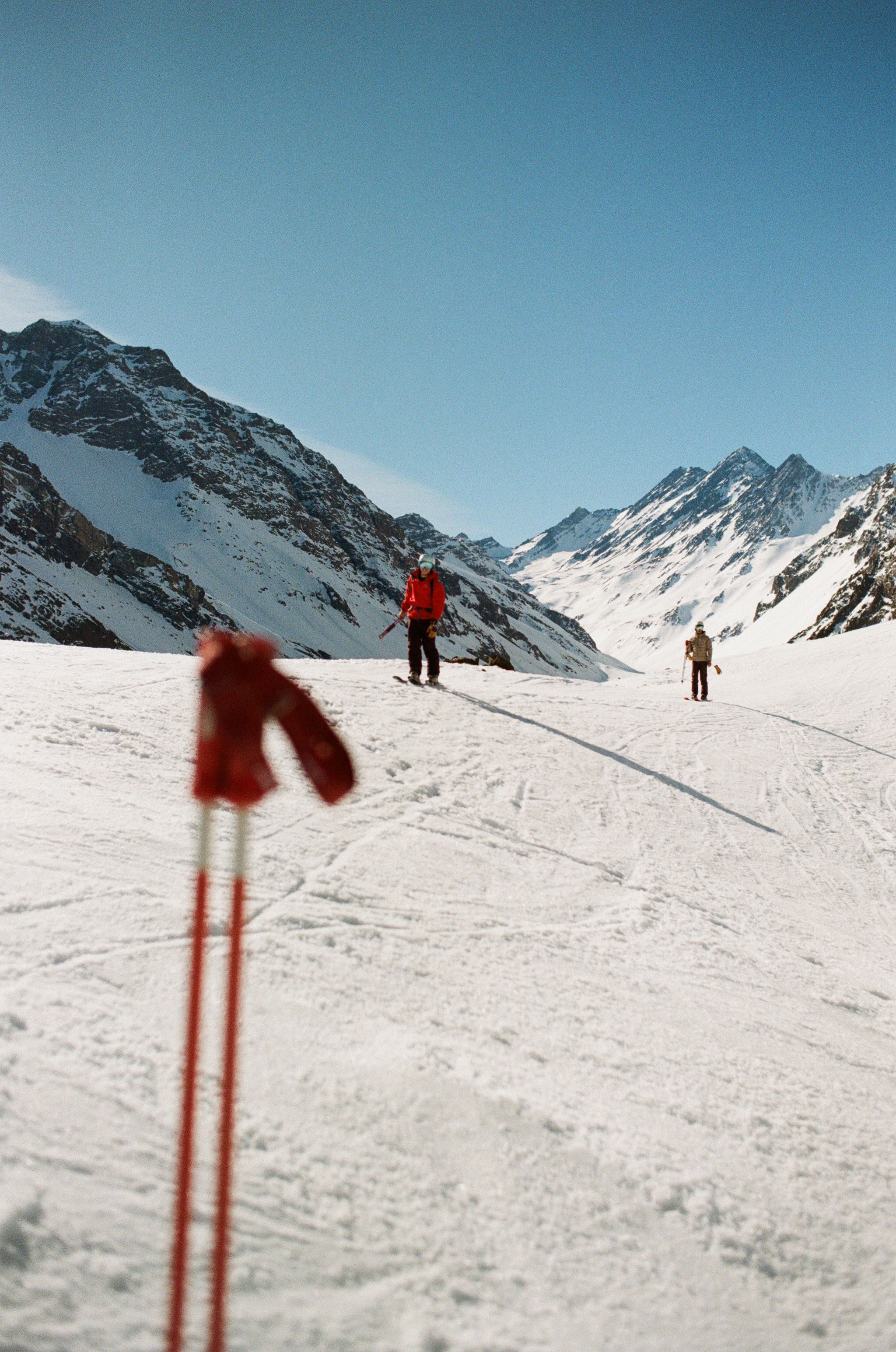 An image of a mountain with ski poles in the foreground
