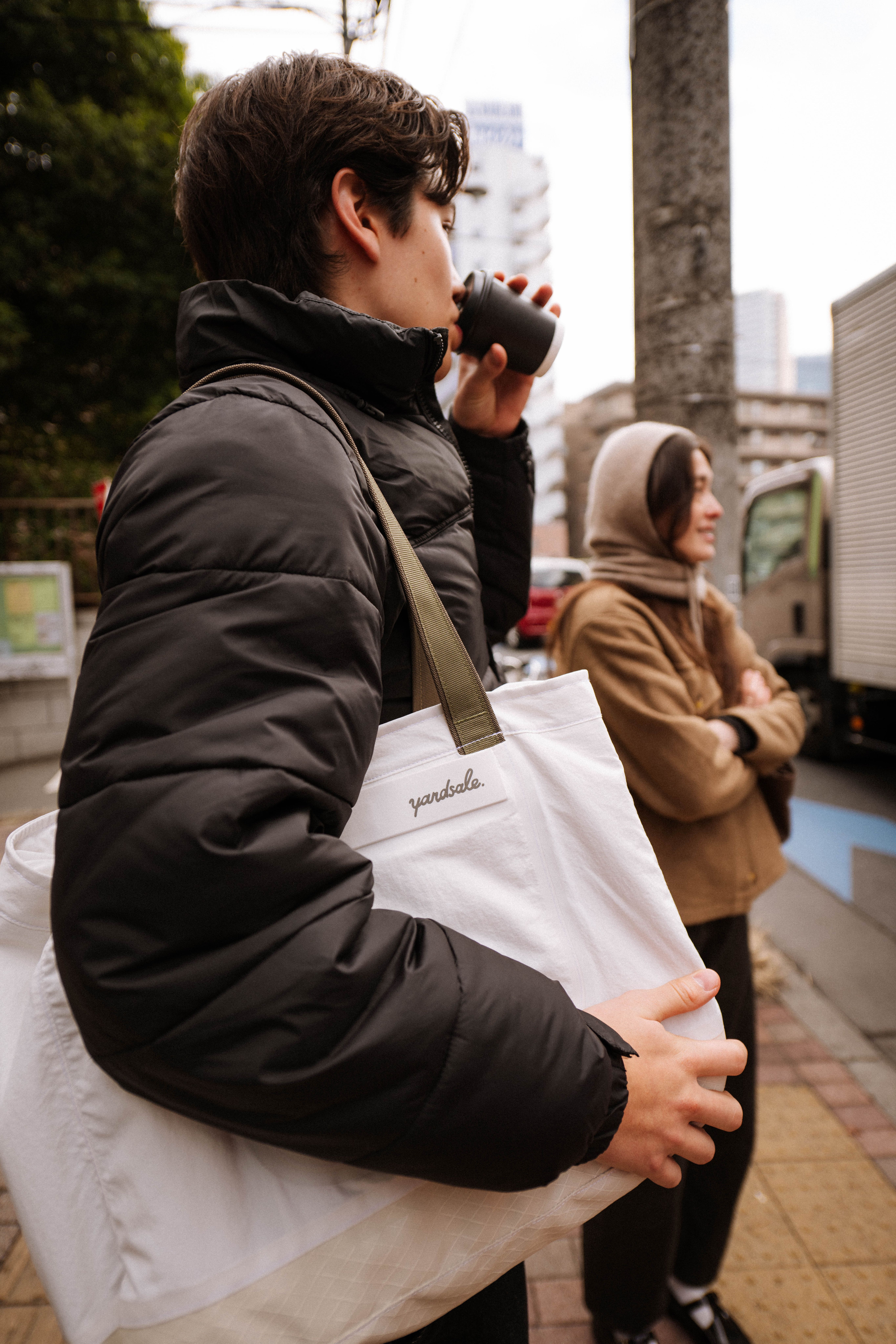 Image of a man drinking coffee in Tokyo with a 20L Day Bag
