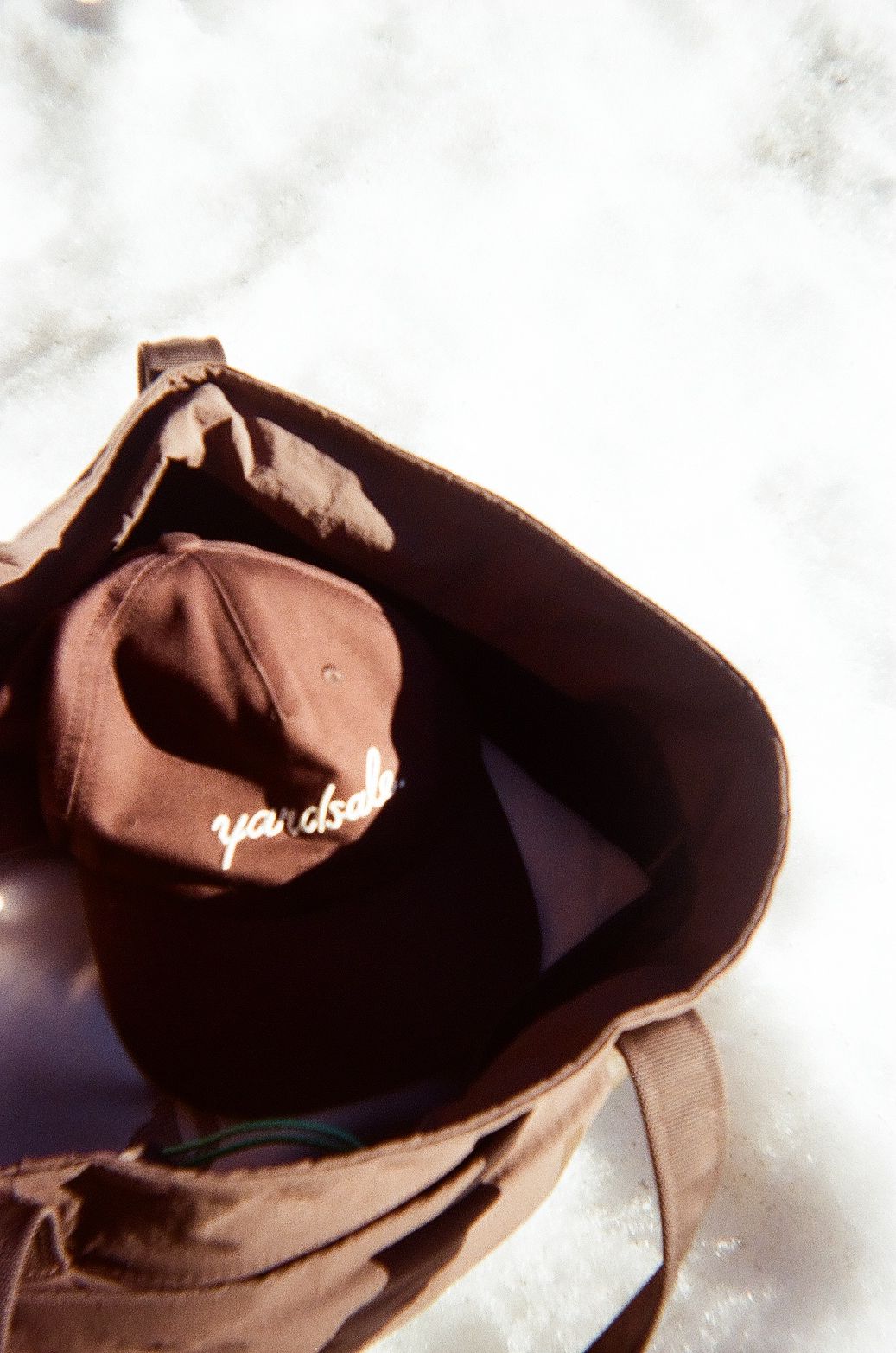 An image of a bag with a hat inside on top of snow