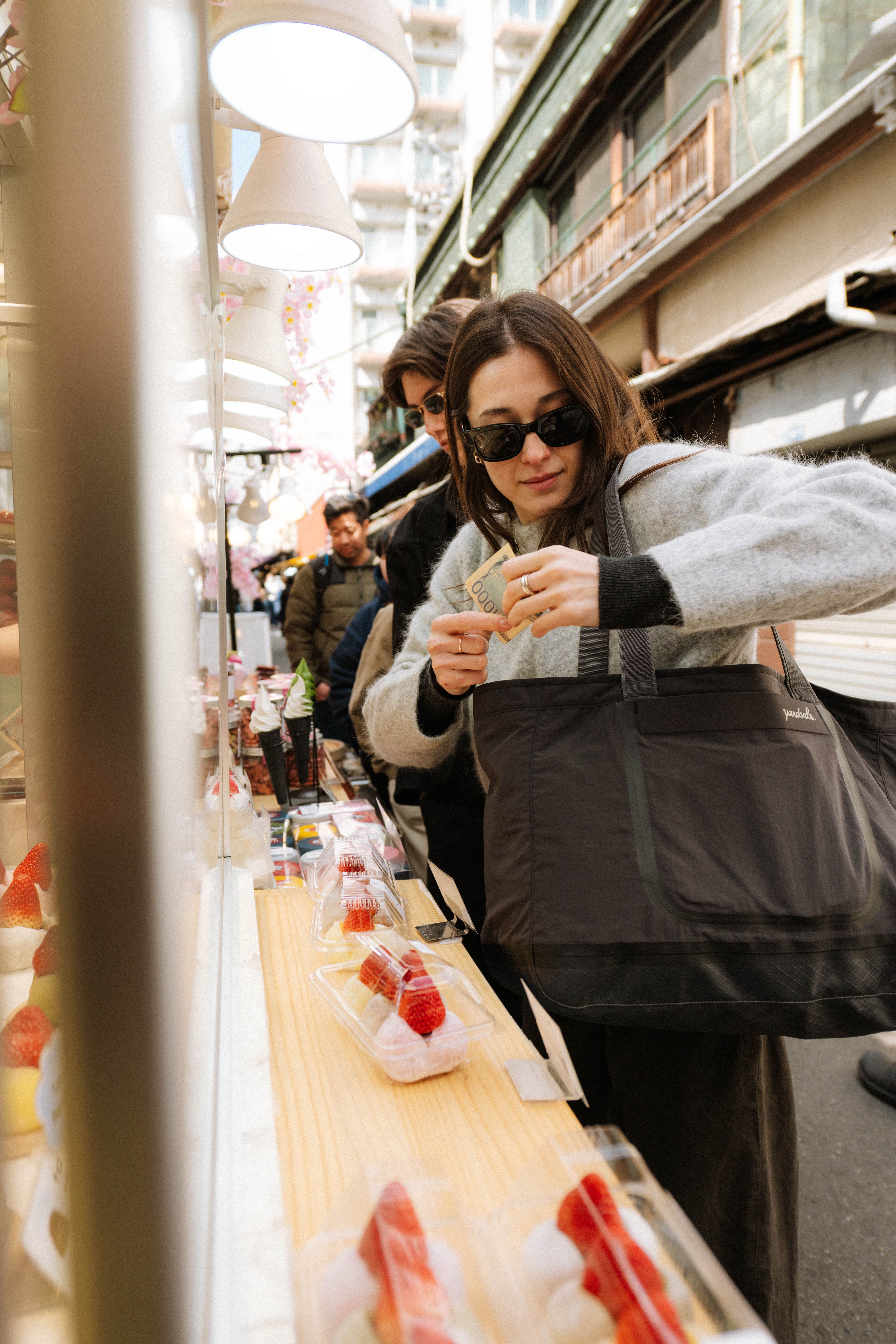 An image of a woman holding a 20L Day Bag in Tokyo