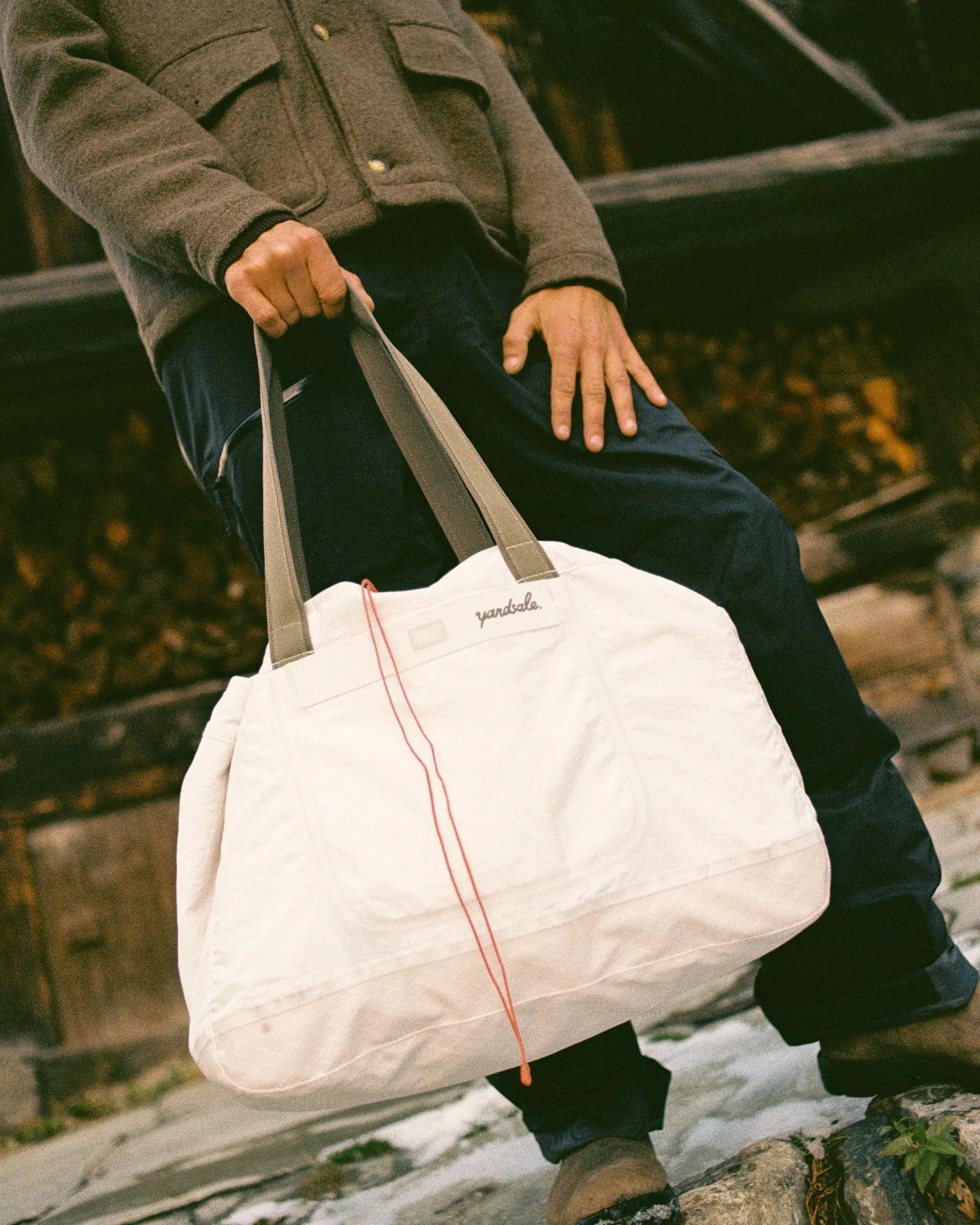 An image of a man holding tote bag