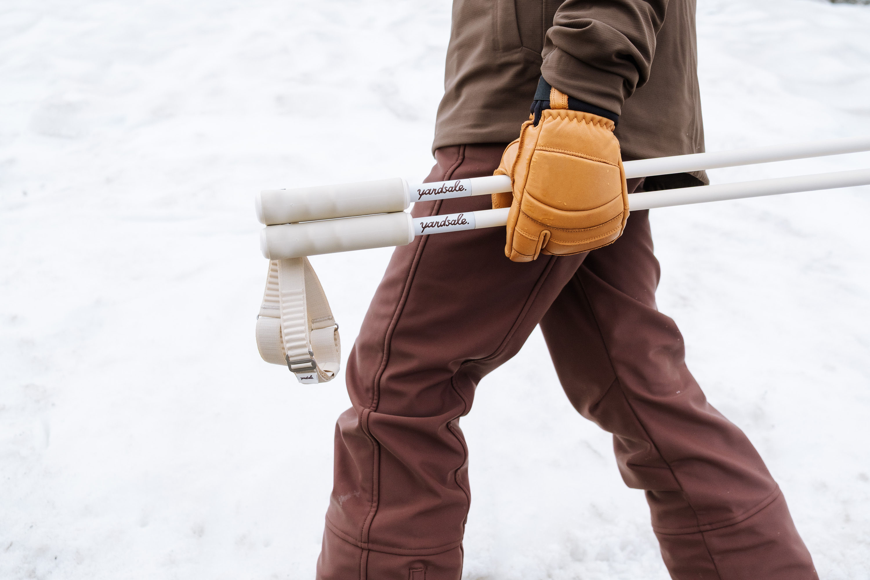 An image of someone carrying ski poles horizontally