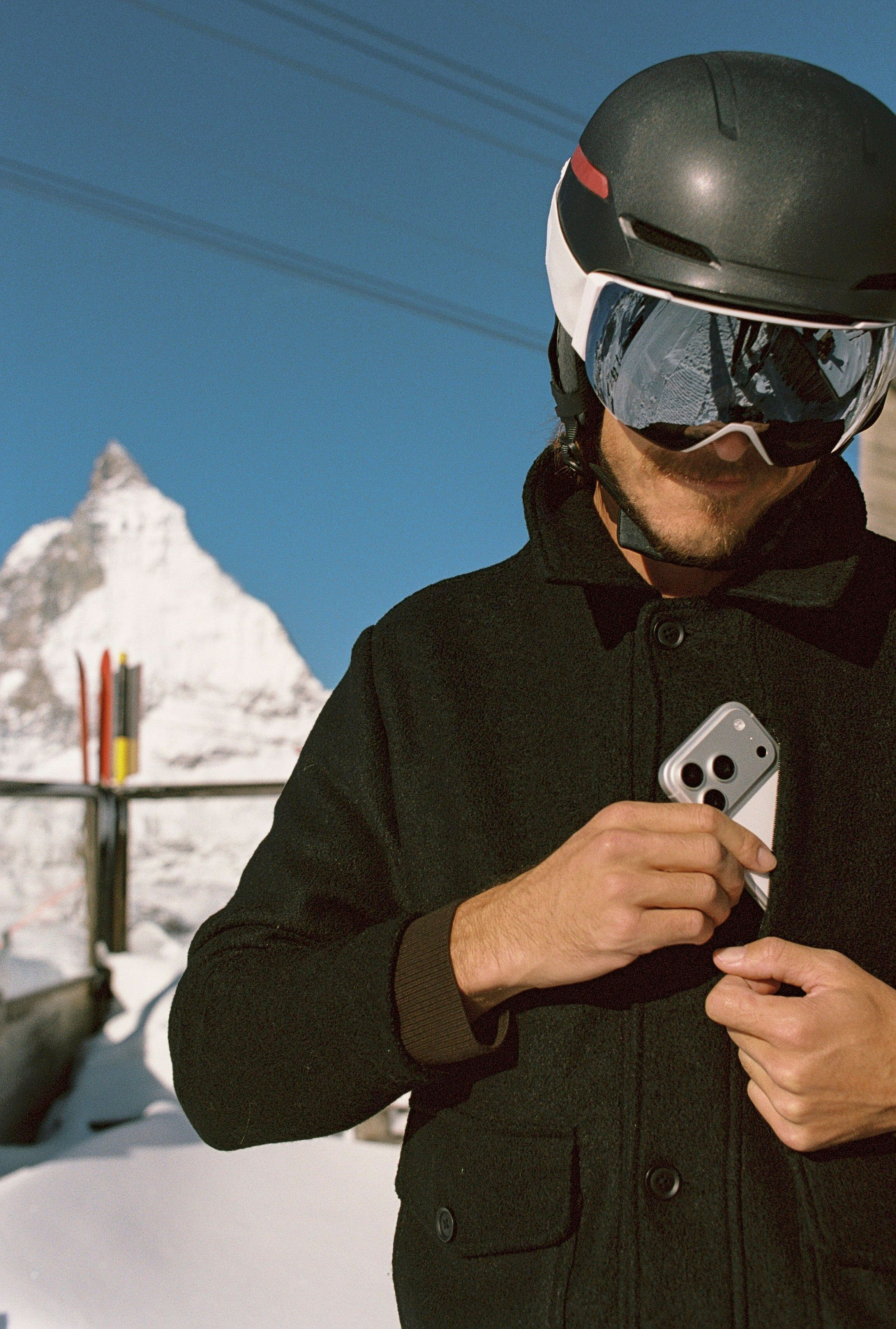 An image of someone putting a phone into a zippered pocket