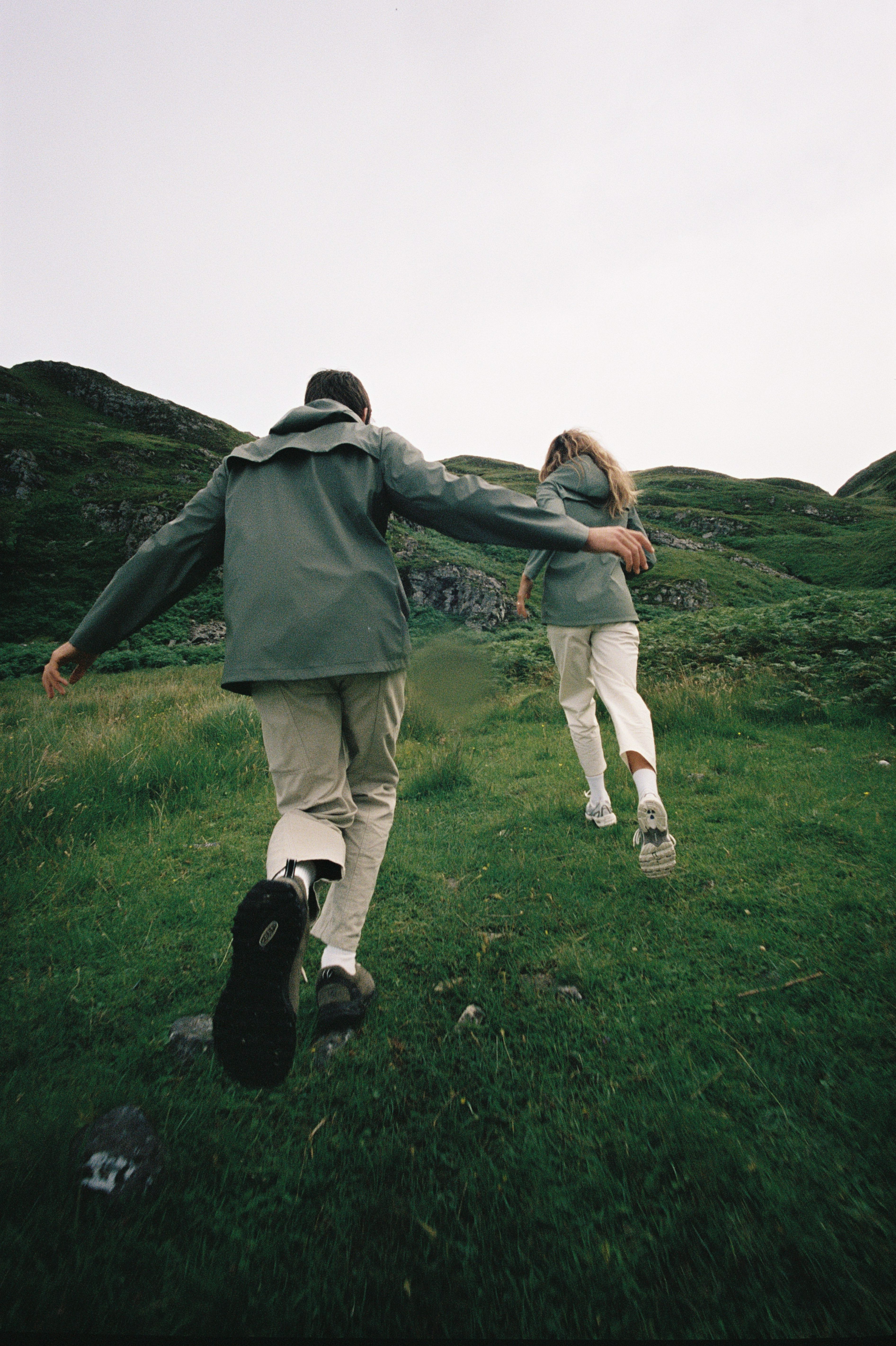 People running up a hill in rain coats