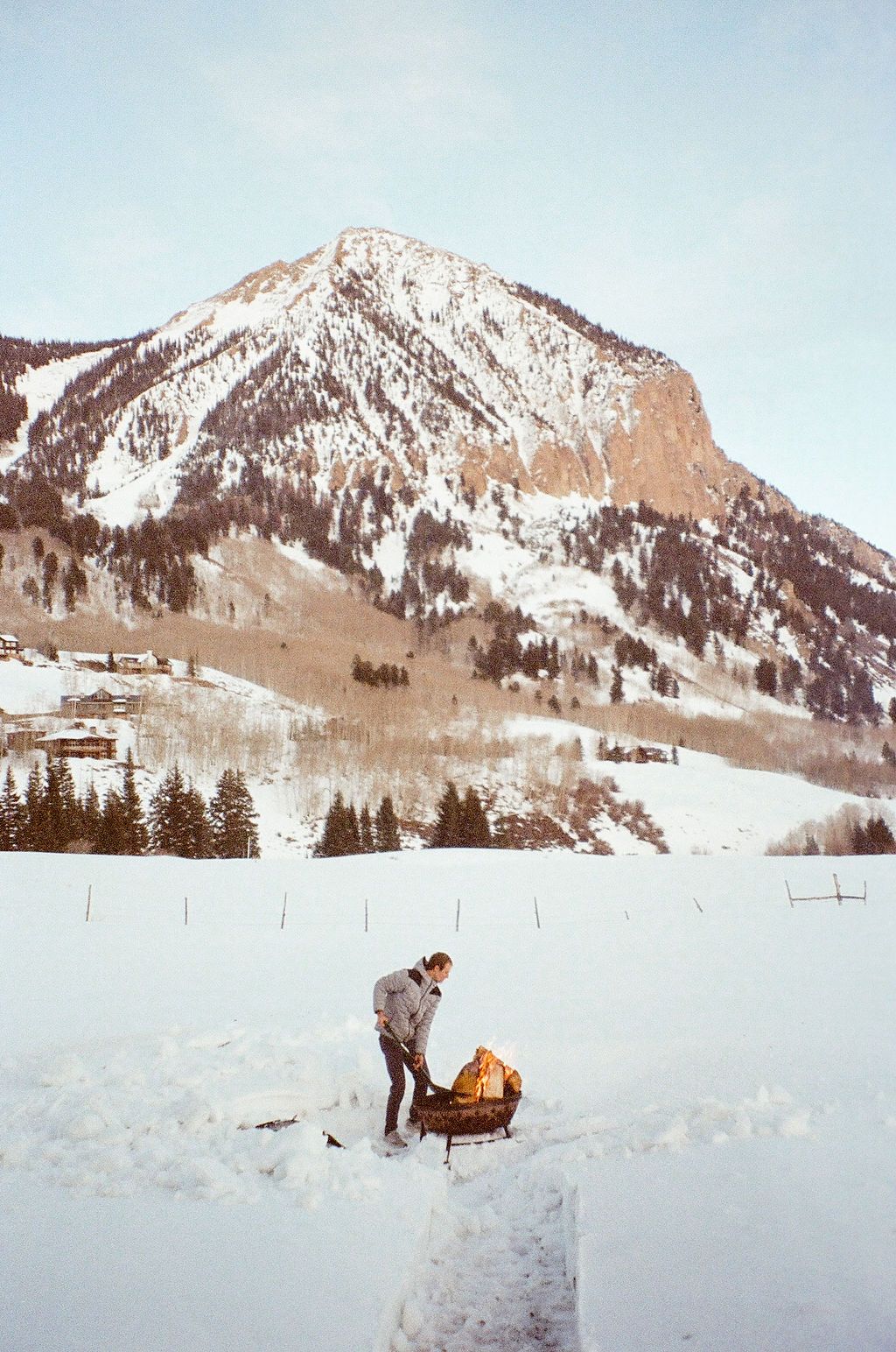 An image of someone building a fire in the mountains