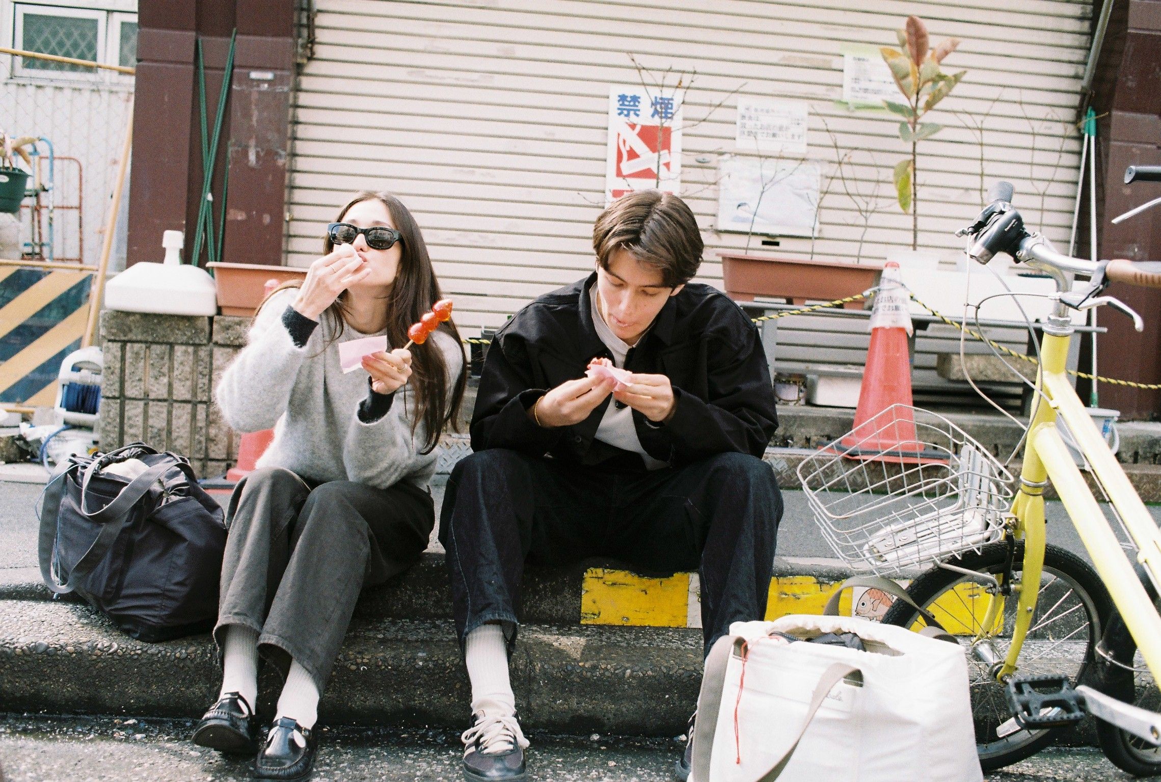 An image of people eating a snack on the curb