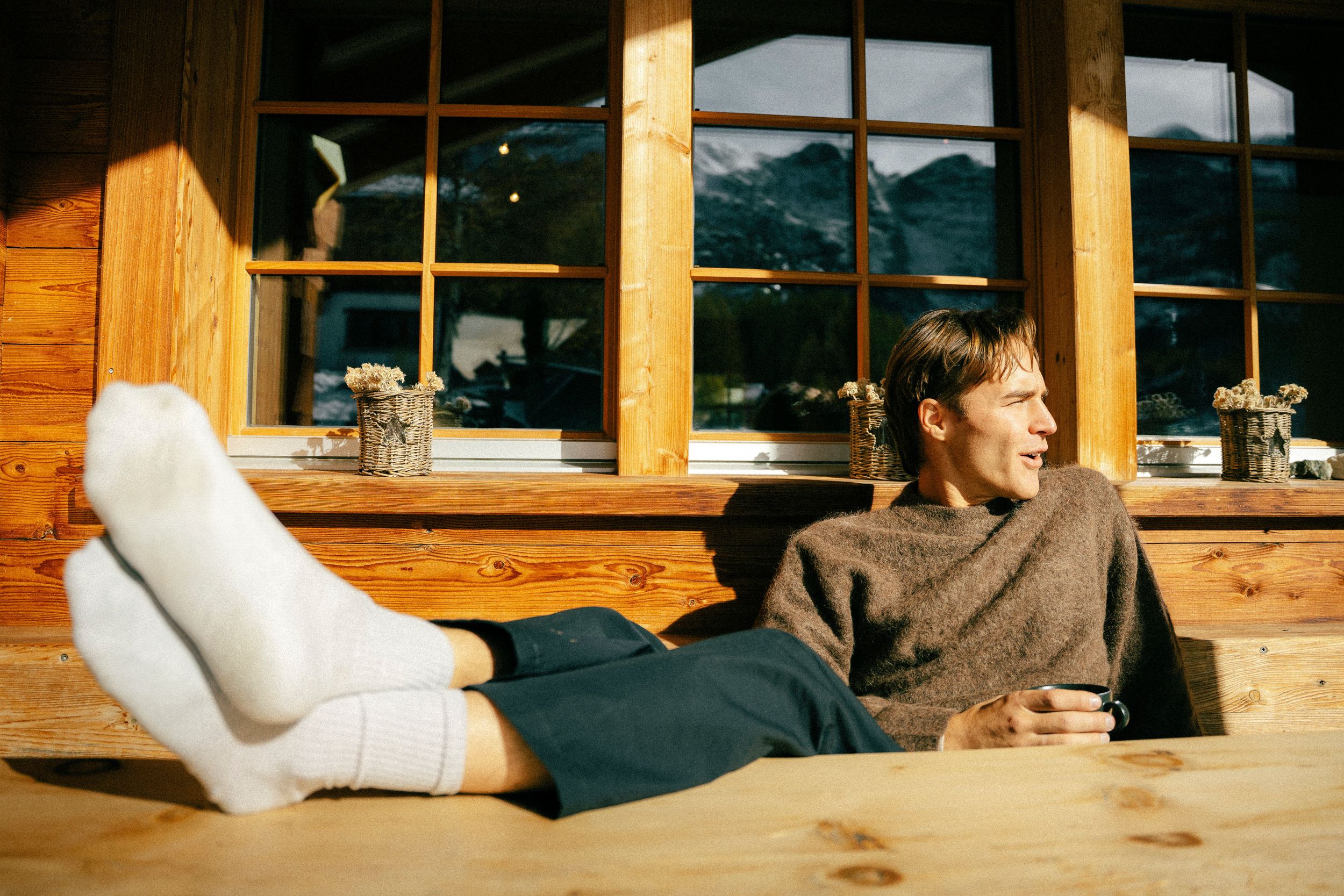 An image of a man lounging in a Dinner Sweater