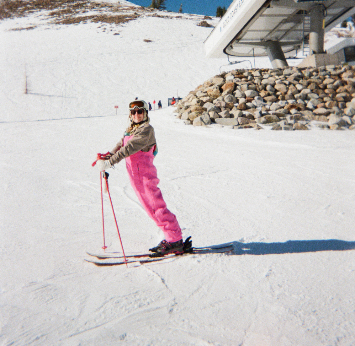 An image of a skier with pink ski poles