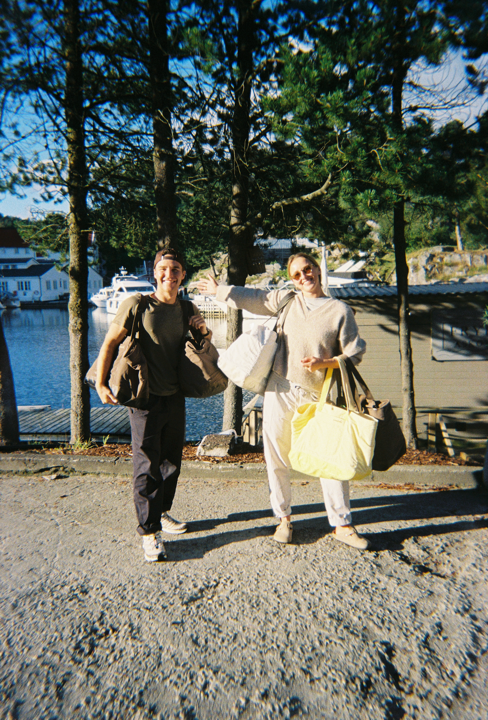 Two people smiling with day bags